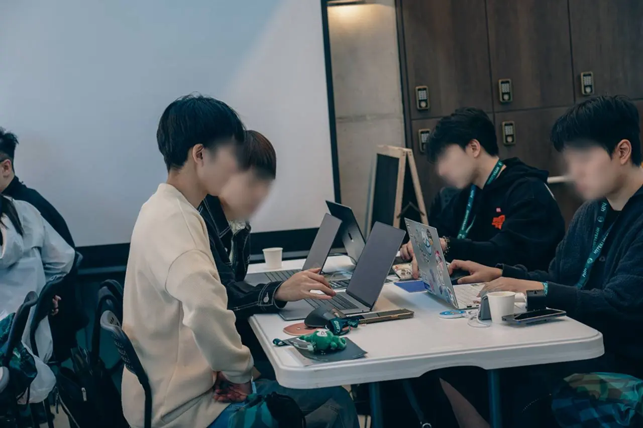 Attendees working together on laptops at a Hyperliquid event
